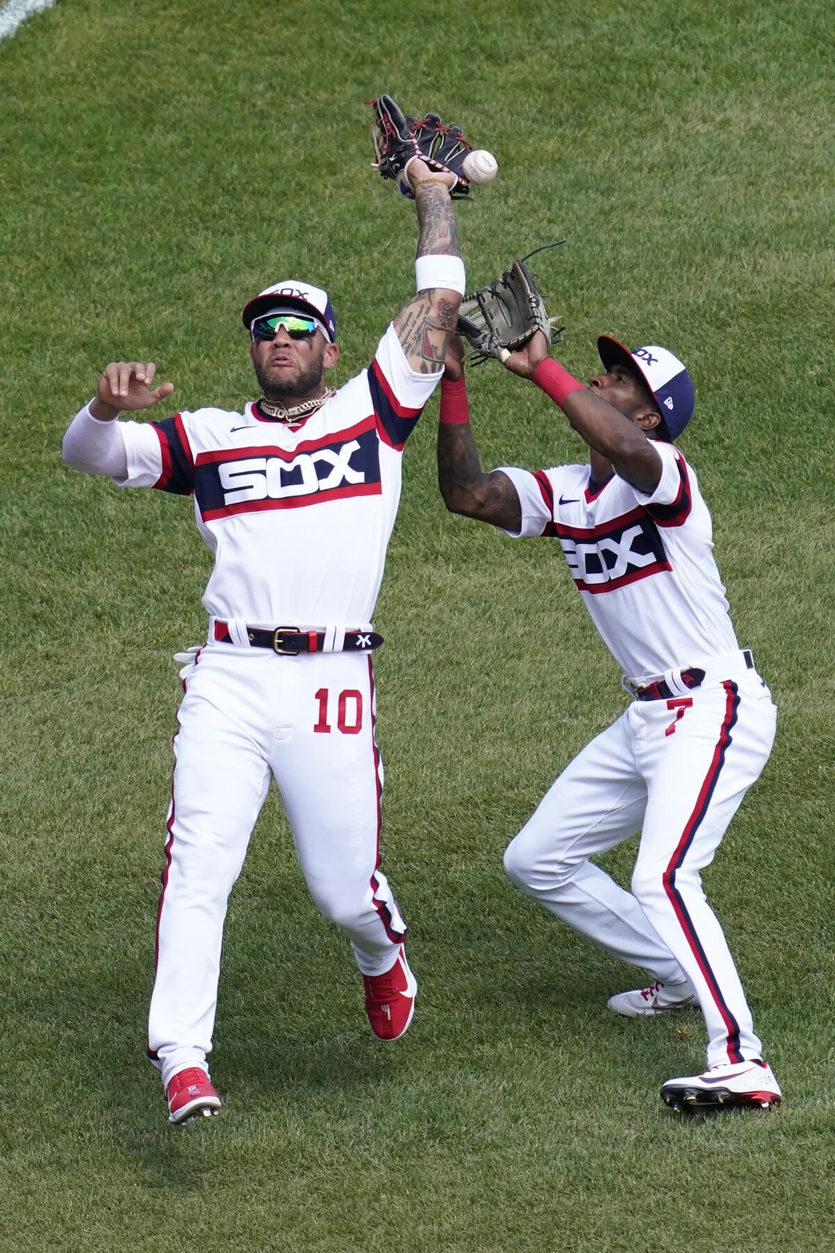 Chicago White Sox third baseman Yoan Moncada, left, makes a fielding error as teammate Tim Anderson, right, watches the ball during the fourth inning of a baseball game in Chicago, Sunday, May 2, 2021. (AP Photo/Nam Y. Huh)