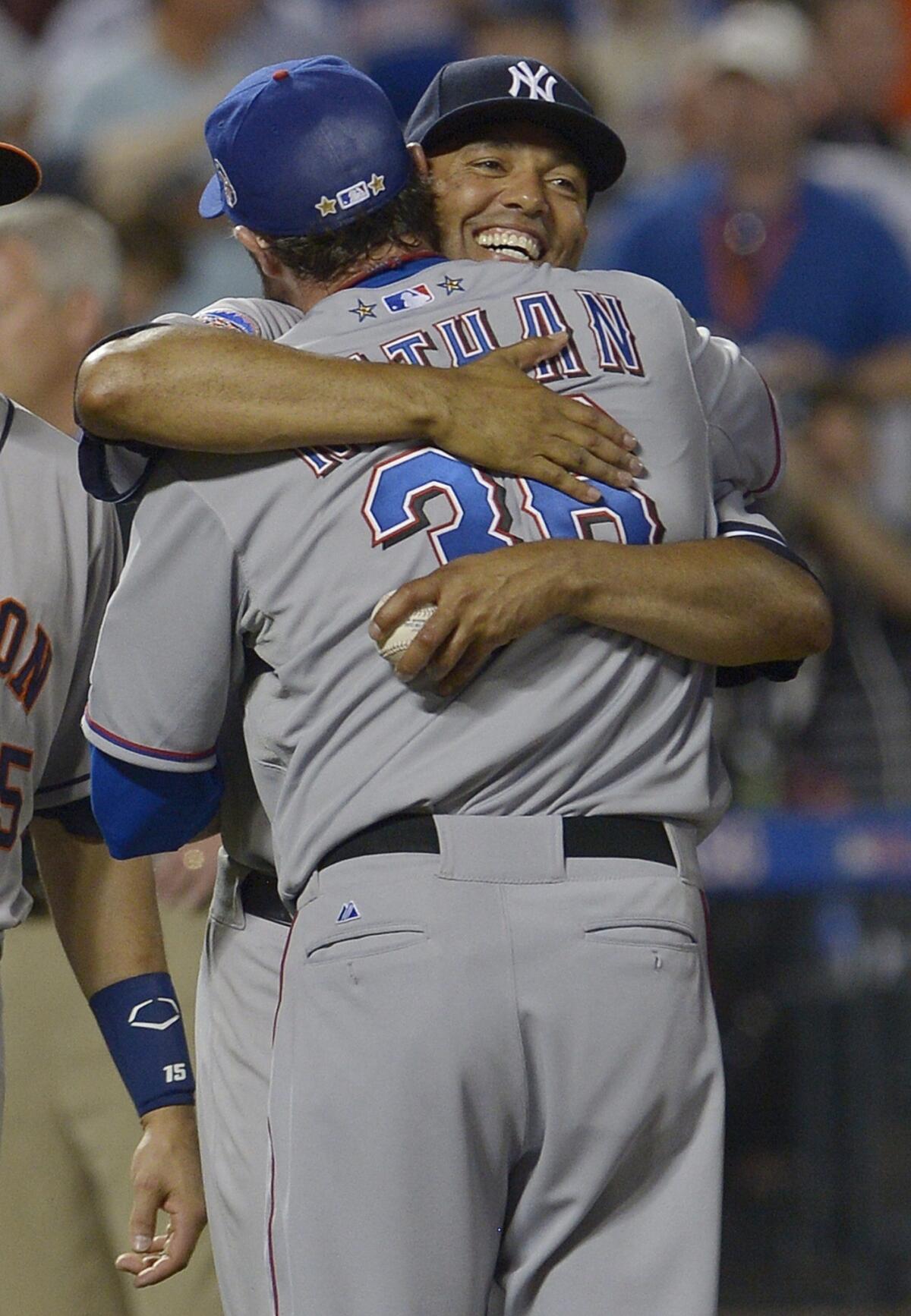 Texas Rangers reliever Joe Nathan is hugged by Mariano Rivera of the New York Yankees after closing out the American League's 3-0 victory over the National League in the MLB All-Star Game on Tuesday.