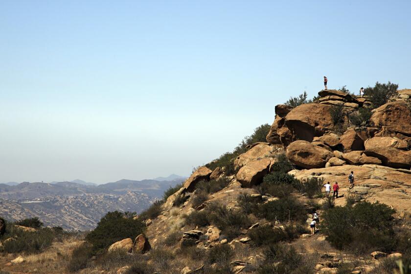 Photographed from the junction of the Hummingbird trail and the Rocky Peak trail, hikers climb the rocks off of the Hummingbird trail.