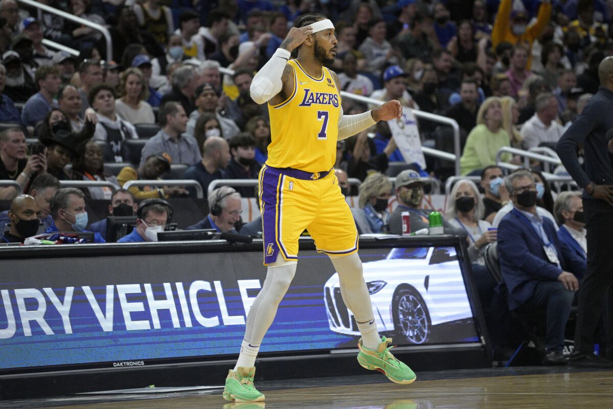 The Lakers' Carmelo Anthony heads back down the court after making a three-pointer Friday.