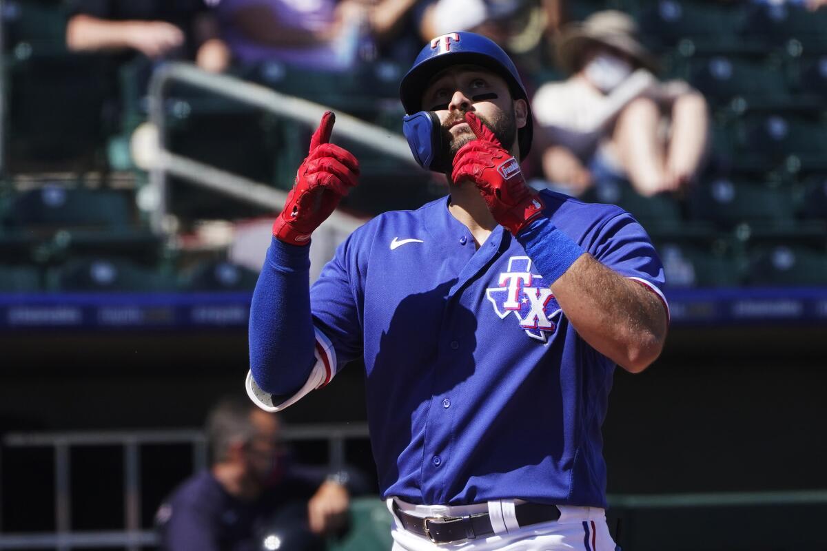 Texas Rangers' Joey Gallo gestures as he crosses home plate on a home run during the first inning of the team's spring training baseball game against the Cleveland Indians, Tuesday, March 9, 2021, in Surprise, Ariz. (AP Photo/Sue Ogrocki)