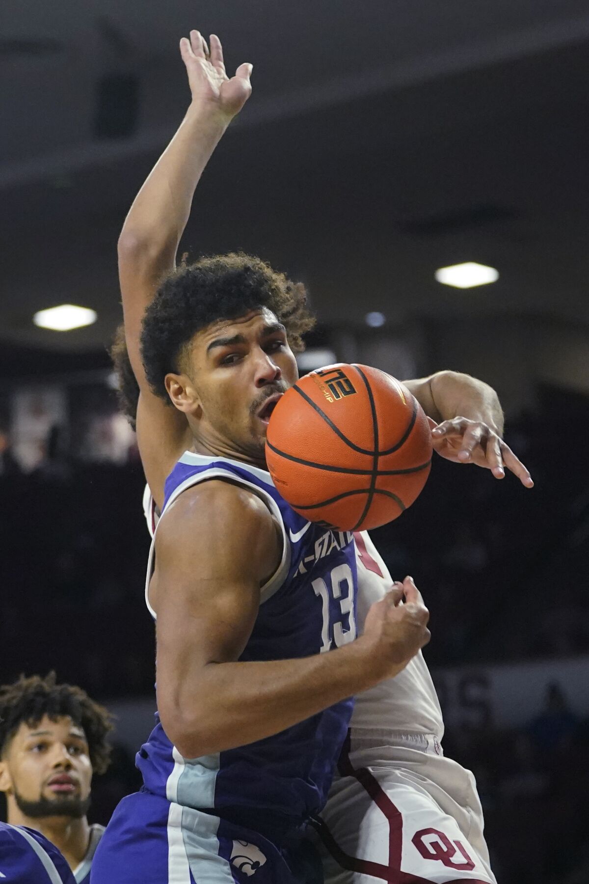 Kansas State guard Mark Smith (13) reaches for a rebound in front of Jalen Hill, rear, in the second half of an NCAA college basketball game Saturday, Jan. 1, 2022, in Norman, Okla. (AP Photo/Sue Ogrocki)