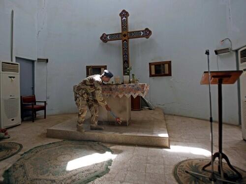 An Iraqi army soldier sweeps inside a Christian church in central Baghdad after two bombs detonated overnight.
