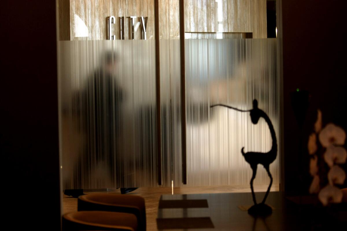 A visitor is seen through frosted door from inside the City Club on the 51st floor of the City National Bank Building.