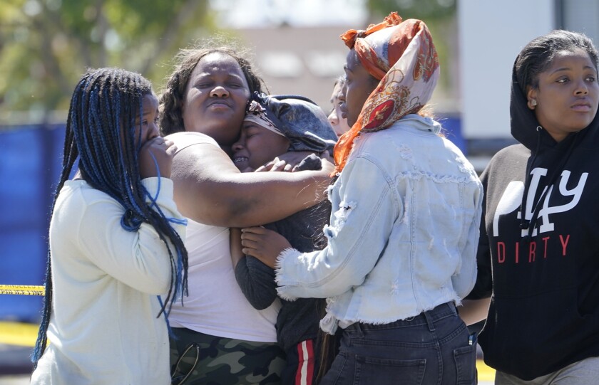 A group of people embrace one another and cry