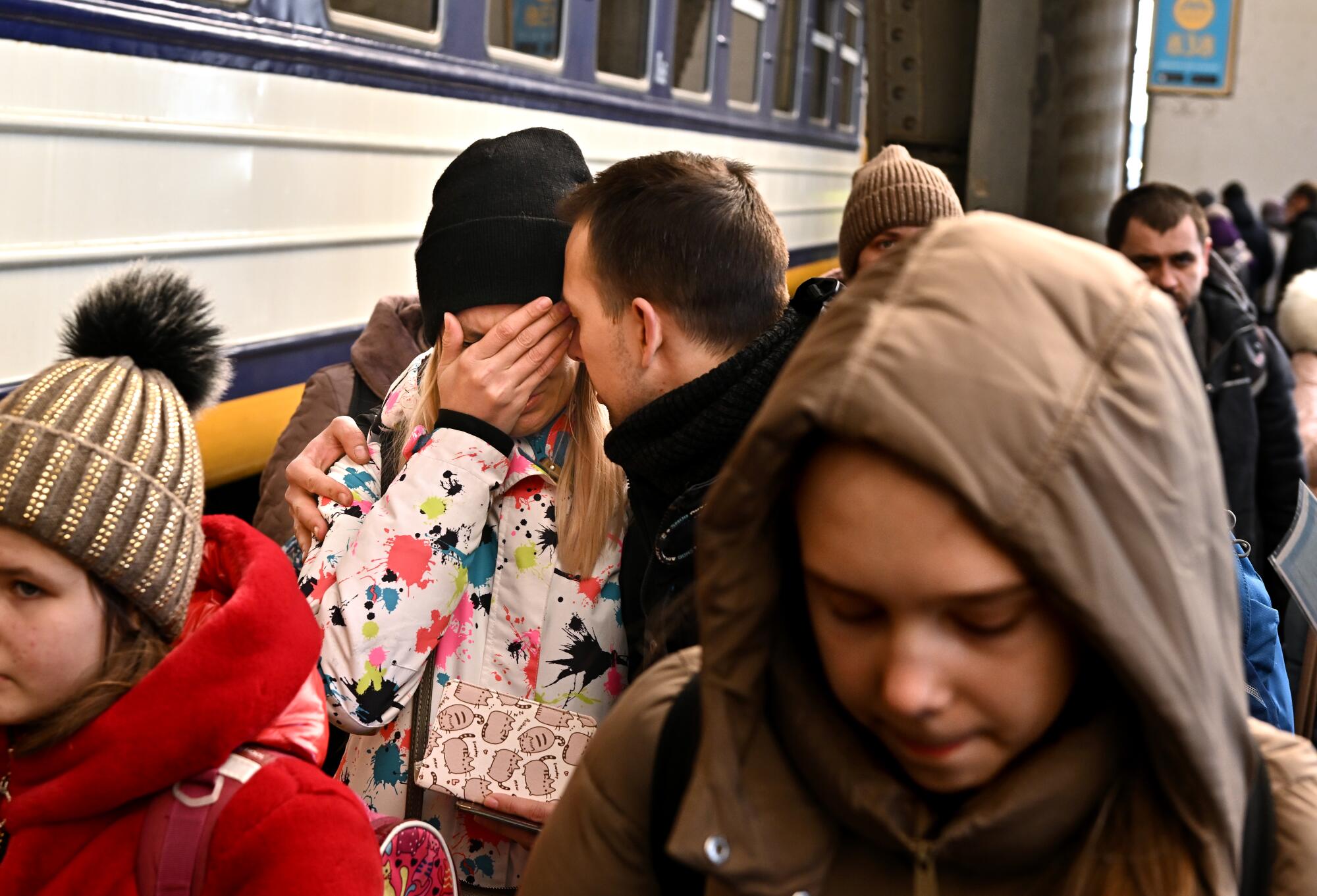 A man comforts his wife in Lviv, Ukraine before she boards a train to Przemysl, Poland. 