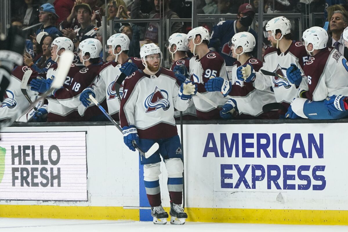 Colorado Avalanche's J.T. Compher, center, is congratulated for his goal during the second period of an NHL hockey game against the Los Angeles Kings on Tuesday, March 15, 2022, in Los Angeles. (AP Photo/Jae C. Hong)