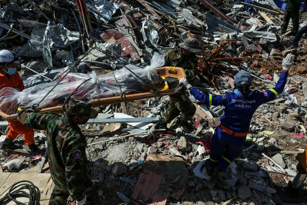Rescue workers recover the body of a victim from the debris of an under-construction building two days after it collapsed in Sihanoukville early on June 24, 2019. - The retrieval of bodies from a building collapse in Cambodia continued on June 24, as the death toll rose to 24 with no further survivors expected to be found under the debris of the seven-storey Chinese-owned construction site.