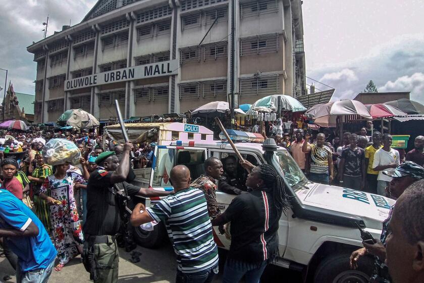 Mandatory Credit: Photo by ISRAEL OPHORI/EPA-EFE/REX (10466023o) Nigerian police arrest a man for suspected looting as two fires engulfed an area of dense buildings at the Balogun market in central Lagos, Nigeria, 05 November 2019. The blaze raged on the top section of a building in the busy Balogun Market. Firefighters were reported to have difficulties in reaching the blaze as access to the site was blocked by market stalls. Fire engulfs market buildings in Lagos, Nigeria - 05 Nov 2019 ** Usable by LA, CT and MoD ONLY **