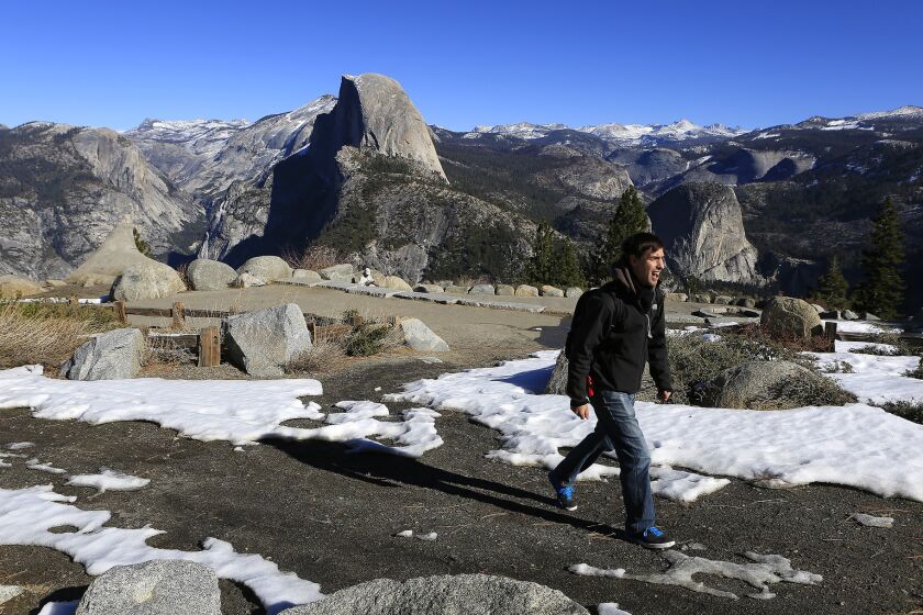 Darrell Carlis of Fresno hikes past patchy snow at Glacier Point in Yosemite National Park on Jan. 23. The arrival of a potentially powerful El Niño this coming winter could rejuvenate the thin Sierra snowpack.