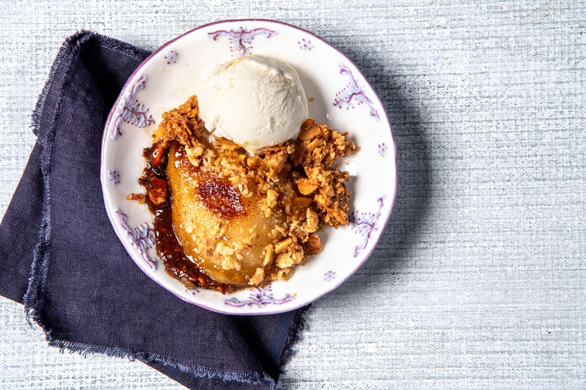 A bowl containing a pear dessert with a scoop of ice cream.