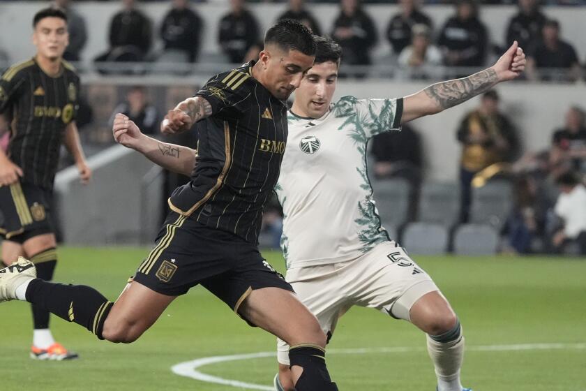 Los Angeles FC forward Cristian Olivera, left, takes a shot on goal as Portland Timbers.