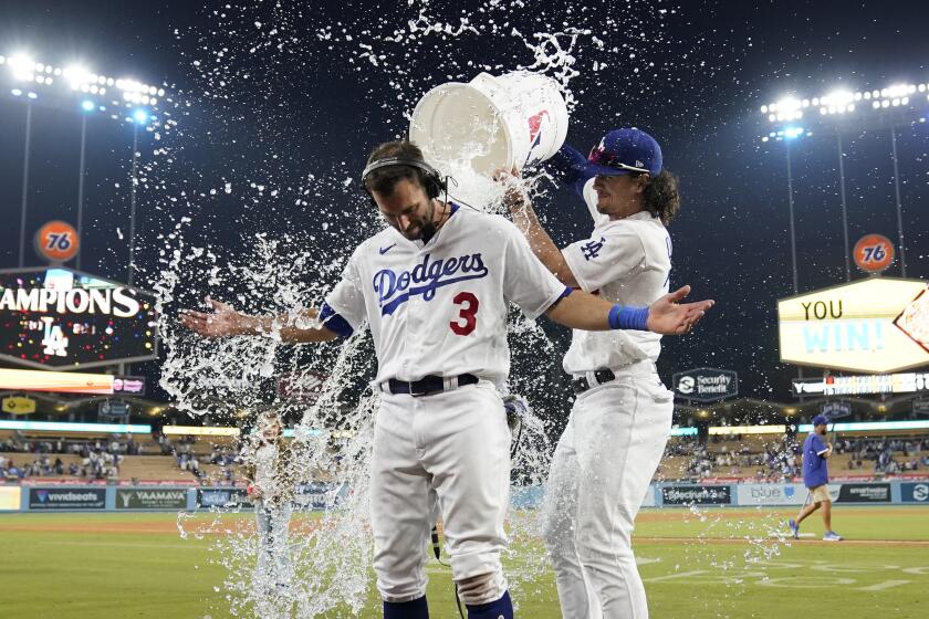 Los Angeles Dodgers' Chris Taylor (3) is doused with water by James Outman.