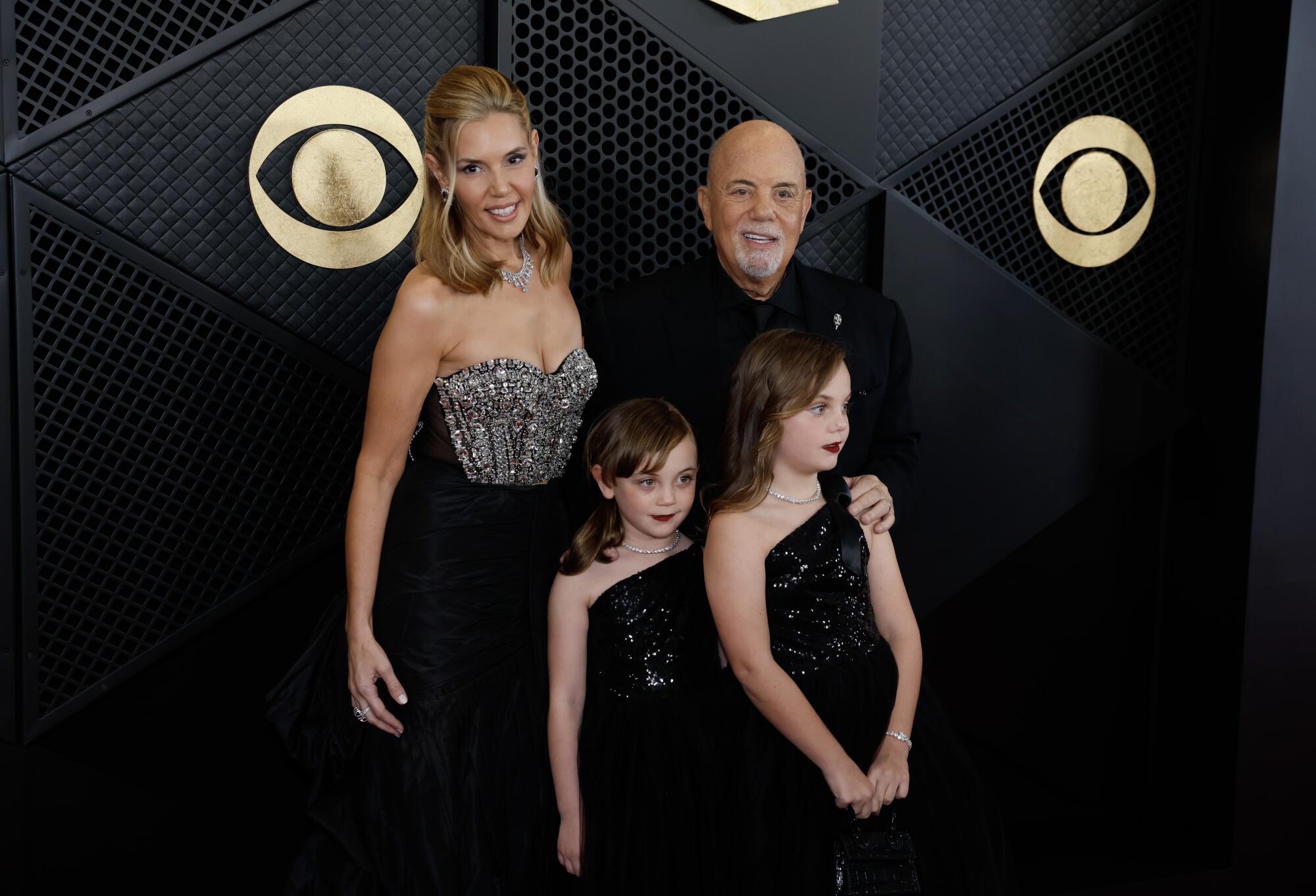 Billy Joel with his wife and their two young daughters, all wearing black 