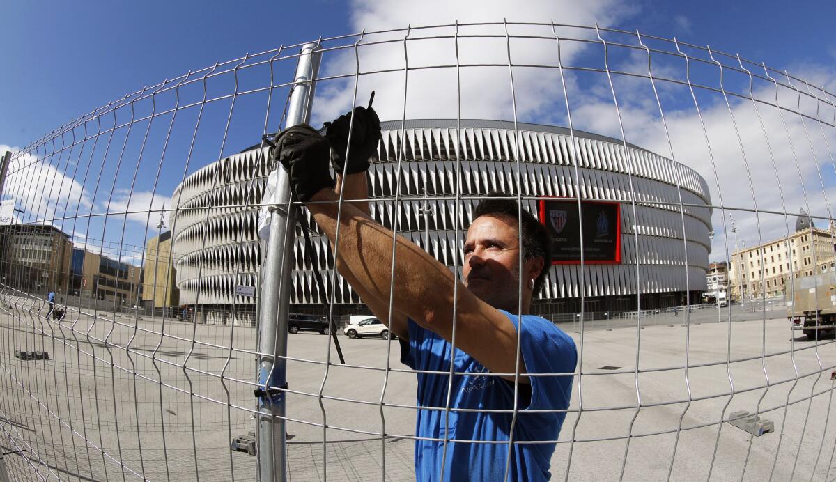 A worker erects a fence around San Mames stadium in order to separate fans in Bilbao, Spain, in 2018.