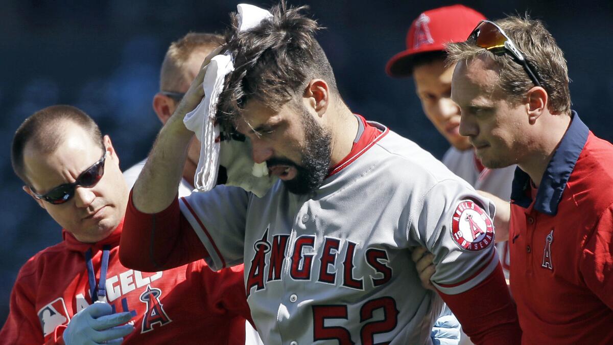 Angels starter Matt Shoemaker is helped off the field Sunday after getting struck by a line drive.