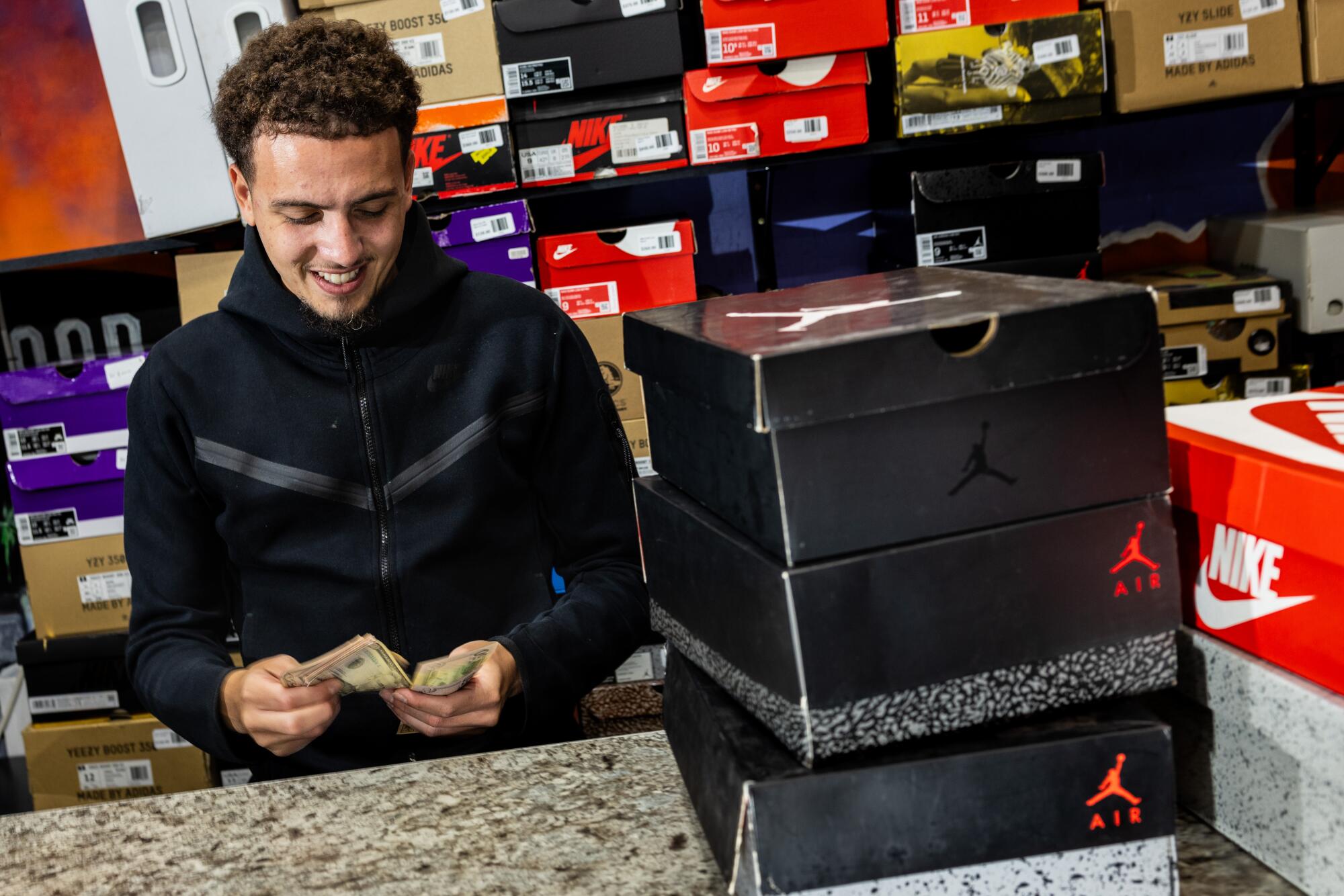 A man at a shoe store counts cash