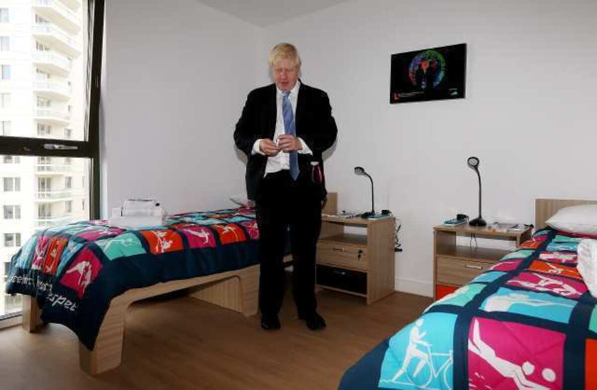 London Mayor Boris Johnson picks up a packet of Olympic-branded condoms during a visit to the Olympic Village on July 12.