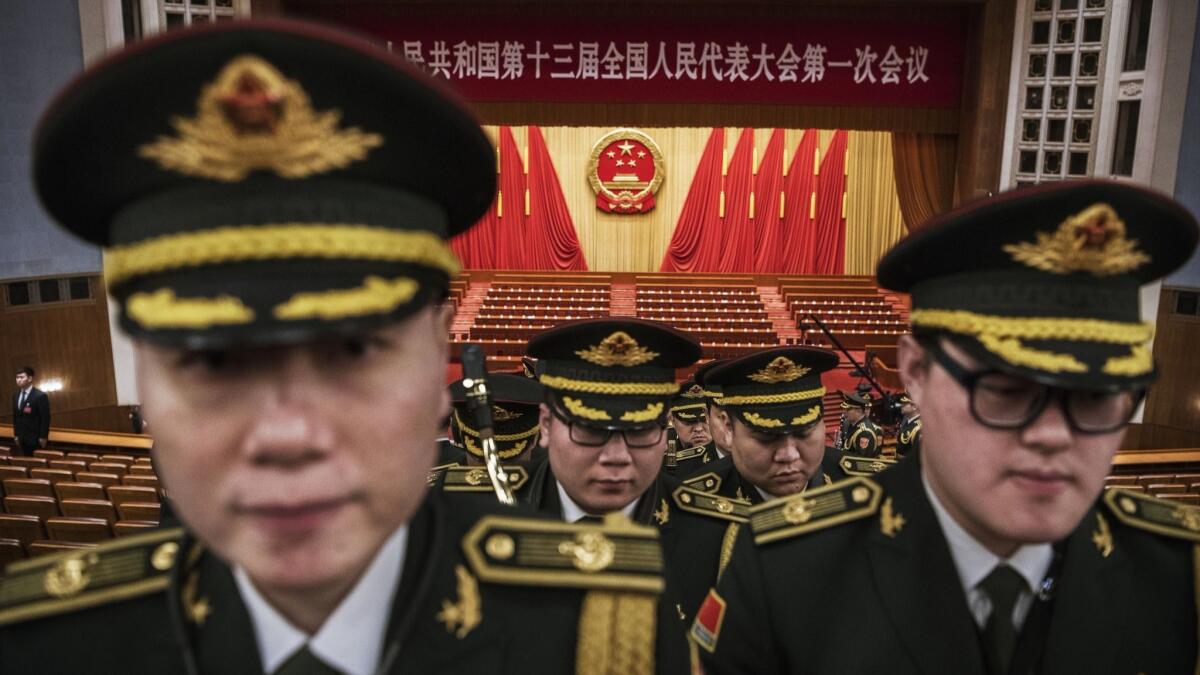 Members of a band from the People's Liberation Army leave following a speech by Chinese President Xi Jinping after the closing session of the National People's Congress in Beijing on March 20, 2018.