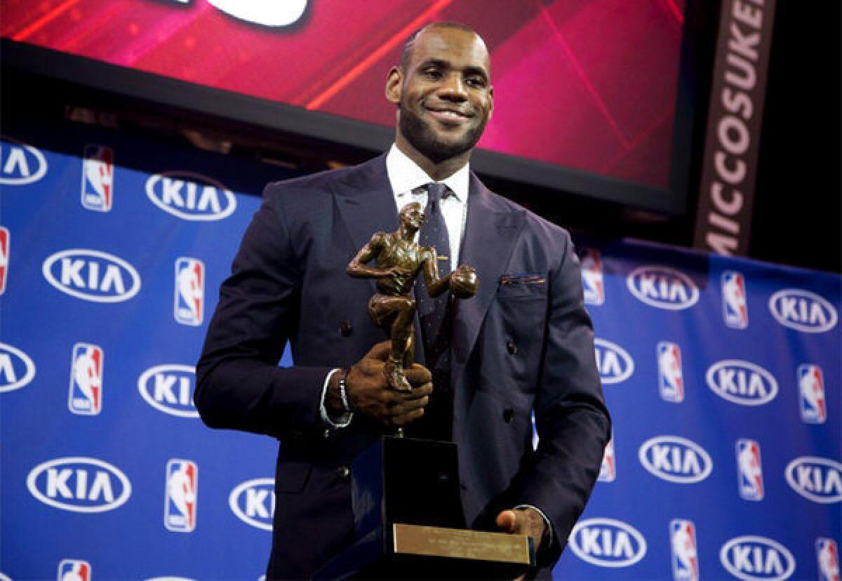 Miami Heat's LeBron James poses for photos after being awarded the NBA's Most Valuable Player award for the fourth time.