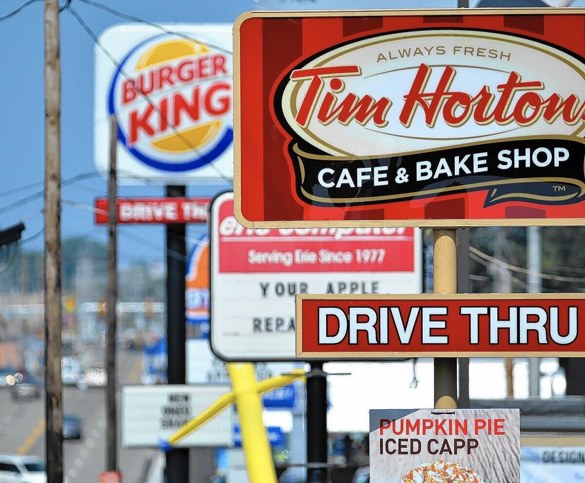Burger King, based in Miami, drew the ire of many consumers and lawmakers when it announced last month that it would acquire Tim Hortons and reincorporate in lower-tax Canada. Above, signs for a Tim Hortons and a Burger King in Erie, Penn.