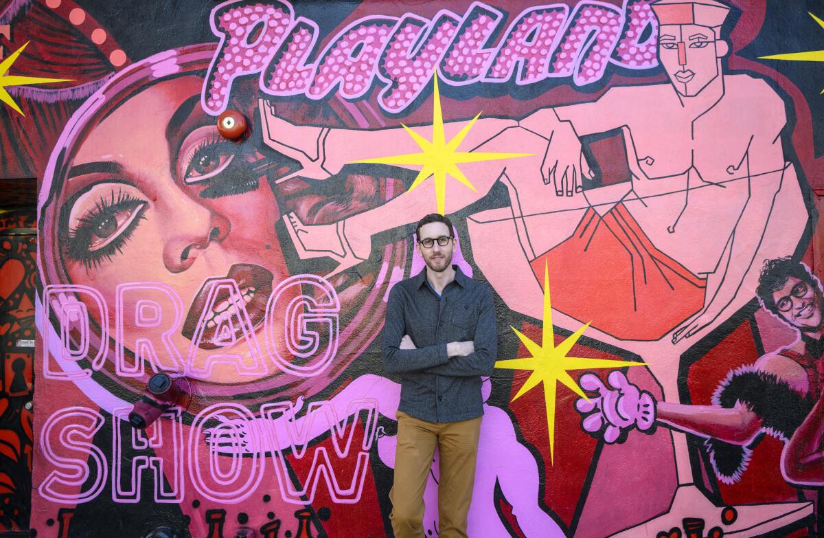 State Sen. Scott Wiener stands in front of a mural.