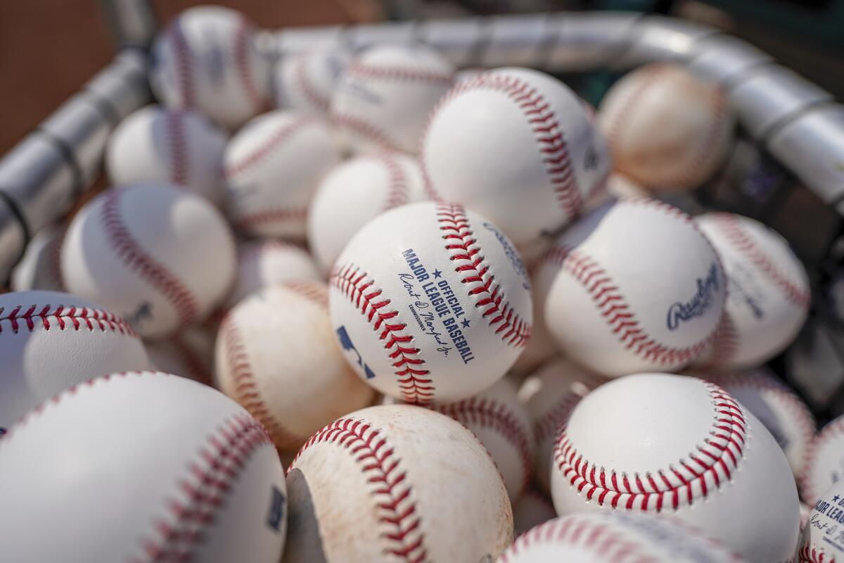 Baseballs are held in a basket on the field before a baseball game.