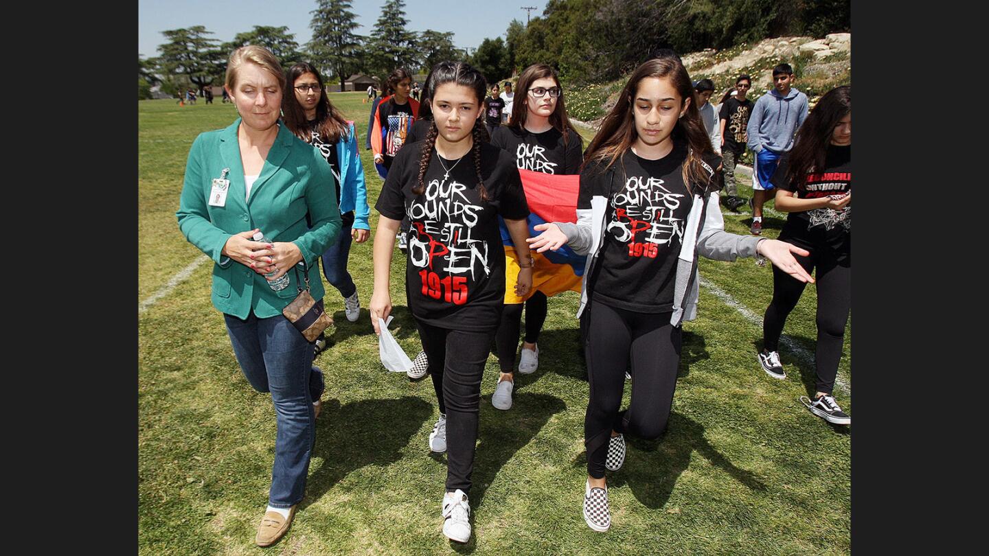 Glendale Unified School District Board Member Jennifer Freemon listens to Nvard Konanyan, 13, and Liana Simonian, 13, as they discuss the Armenian Genocide and the importance of what they are doing now as they circle the upper track at Rosemont Middle School.