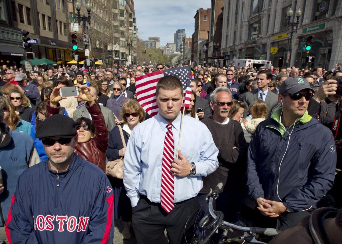 On April 22, 2013, a week after the bombing, Bostonians gather for a moment of silence in tribute to the victims of the marathon bombing on Boylston Street near the race finish line.
