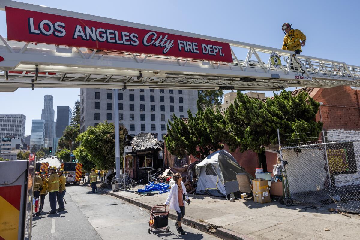 A firefighter walks along a ladder extended from a firetruck