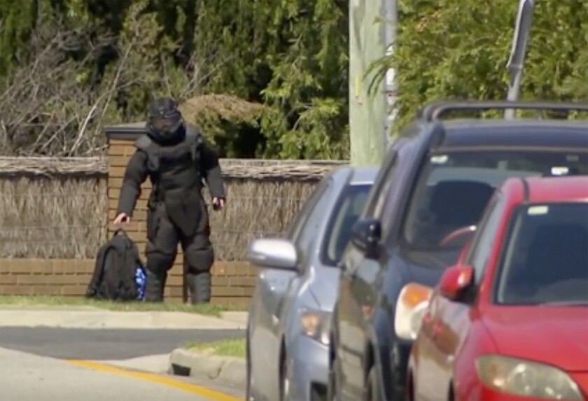 En esta imagen tomada de un video, un miembro del equipo antibombas de la policía llega al lugar de una explosión, el sábado 22 de enero de 2022 en Melbourne, Australia. (Channel 7 via AP)