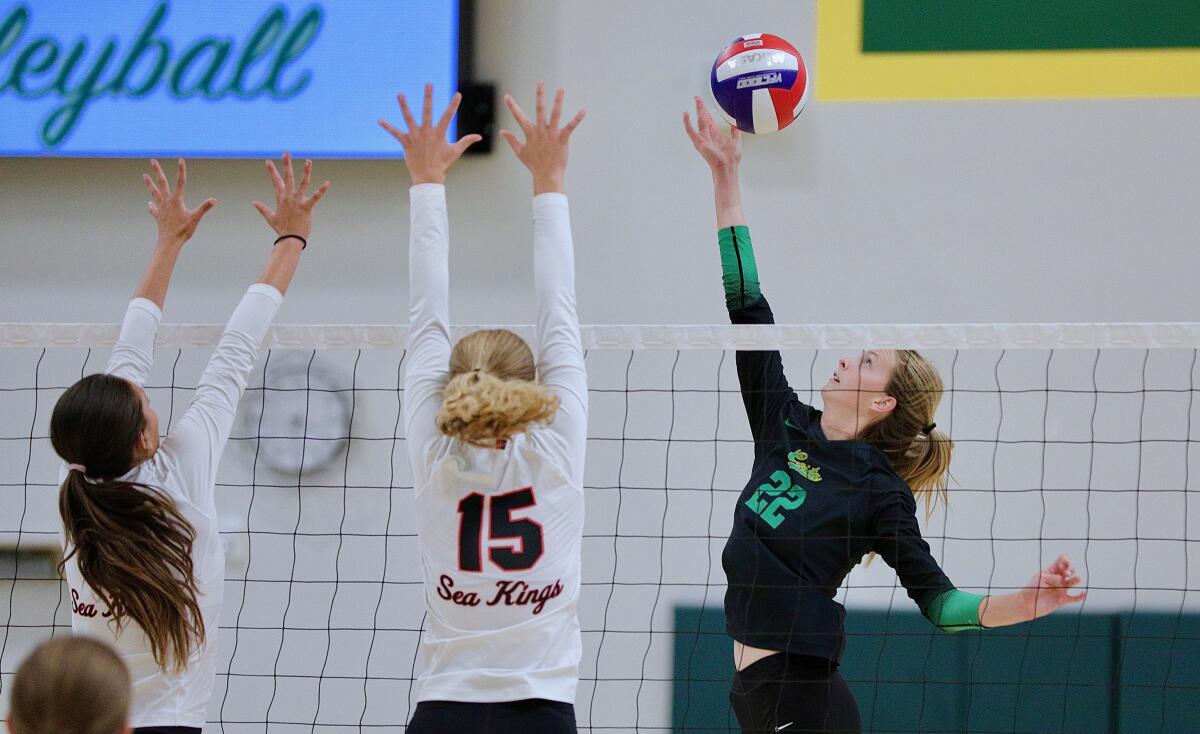 Mira Costa's Audrey Flanagan lofts the ball over a pair of Palos Verdes blockers.