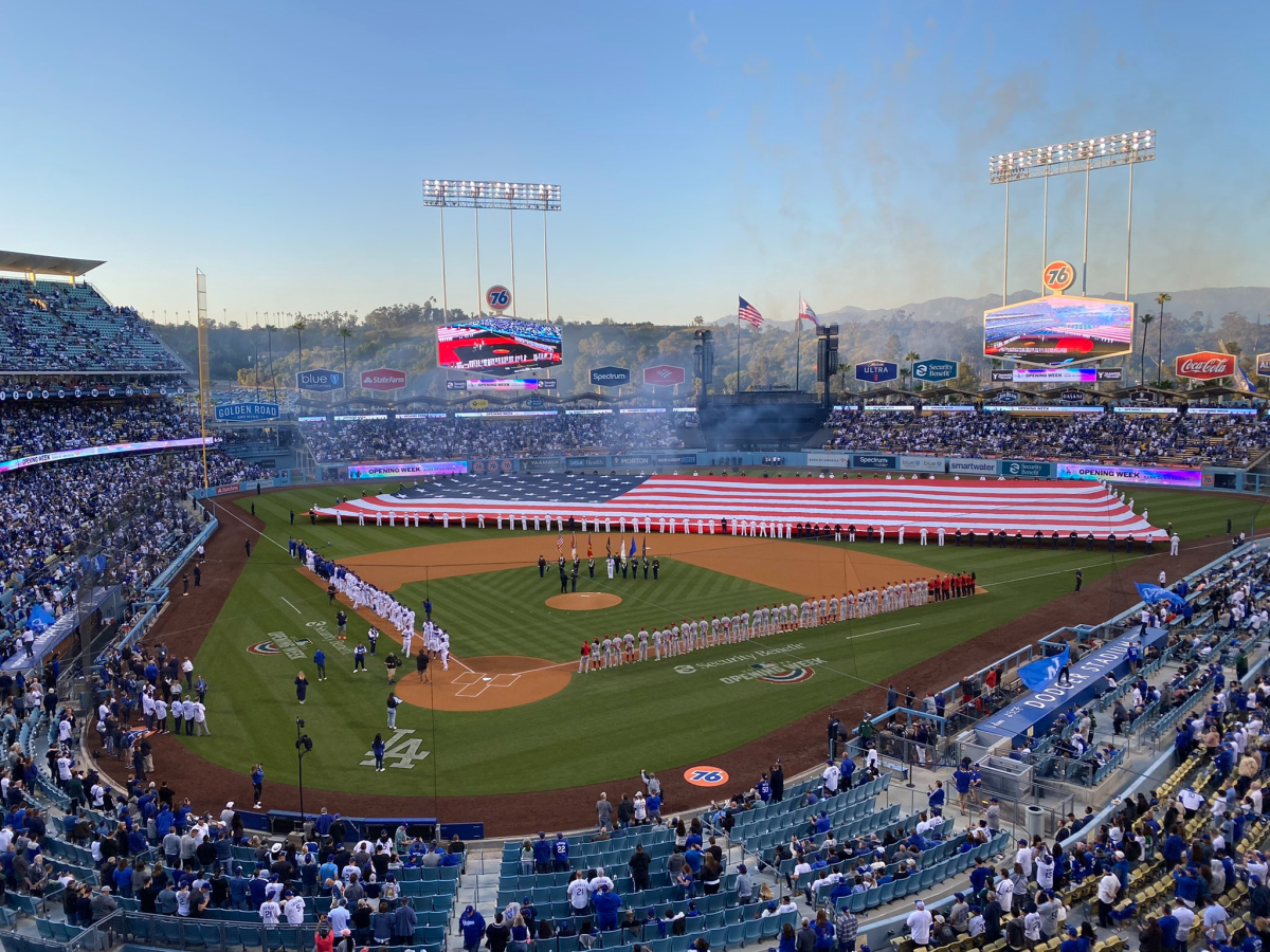 A giant American flag covers the field at Dodger Stadium before the start of the home opener against the Cincinnati Reds.