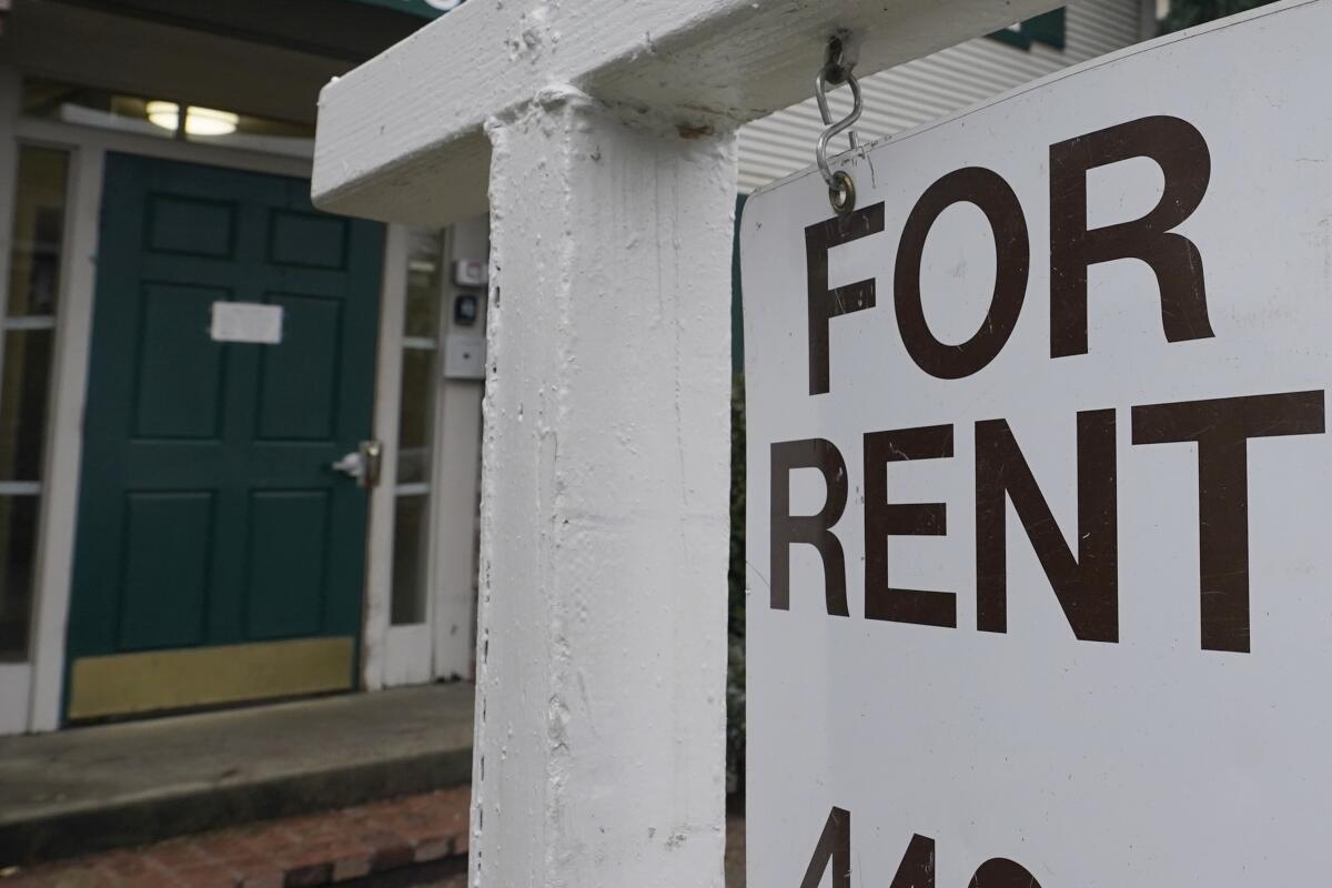 Close-up of a 'For Rent' sign in front of a home
