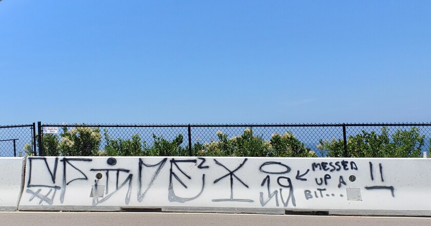 The graffiti painted on a rail along Torrey Pines Road, which was reported in late June, and was still present July 15.