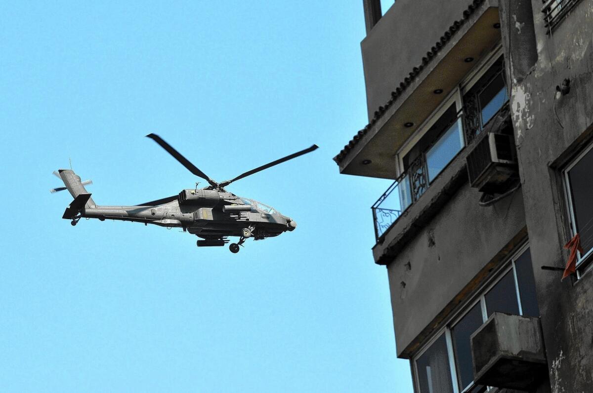 An Egyptian army Apache helicopter flies over supporters of ousted President Mohamed Morsi, unseen, as they demonstrate near Cairo University in July. The U.S. is sending 10 more Apaches to the Egyptian government.