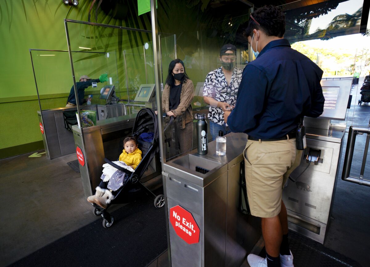A family checks in at the front gate of the San Diego Zoo on Wednesday. 