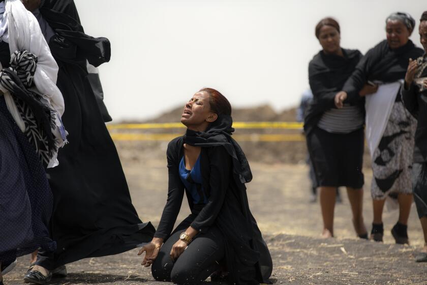 FILE - In this March 14, 2019 file photo, relatives of crash victims mourn at the scene where an Ethiopian Airlines Boeing 737 Max 8 passenger jet crashed shortly after takeoff, killing all 157 on board, near Bishoftu, in Ethiopia. These African stories captured the world's attention in 2019 - and look to influence events on the continent in 2020. (AP Photo/Mulugeta Ayene, File)