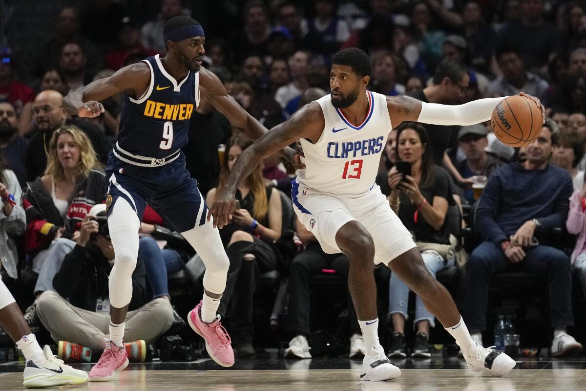 Denver Nuggets guard Justin Holiday defends against Clippers forward Paul George.
