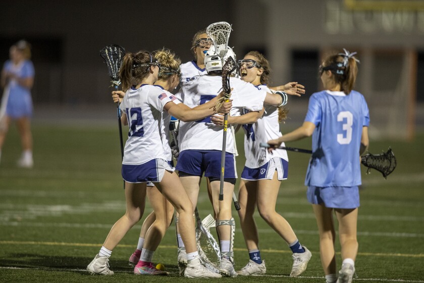 Members of the Newport Harbor girls' lacrosse team hug goalie Lucy Valdez after beating CdM in a CIF Division 2 semifinal.