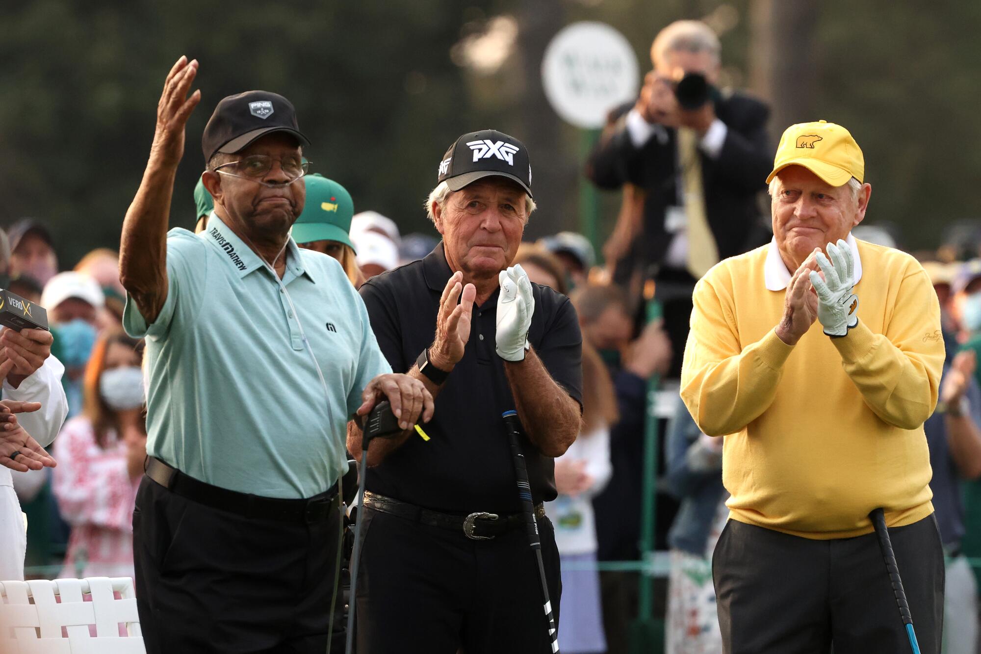 Honorary starter Lee Elder waves to the patrons alongside Gary Player and Jack Nicklaus.