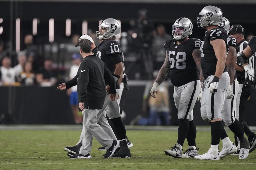 Las Vegas Raiders quarterback Jimmy Garoppolo is helped off the field after being sacked by Pittsburgh Steelers linebacker T.J. Watt during the first half of an NFL football game Sunday, Sept. 24, 2023, in Las Vegas. (AP Photo/Mark J. Terrill)