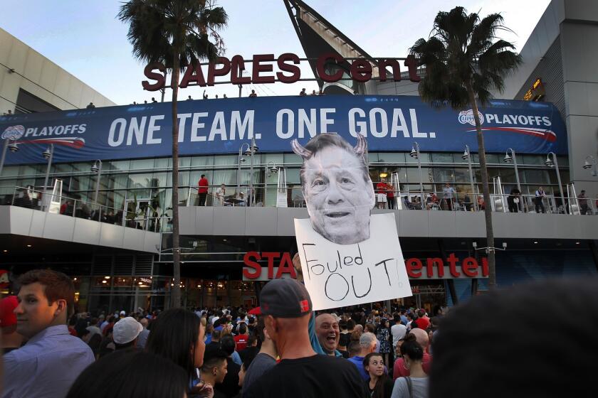 Longtime Clippers fan Abe Dilanian holds a sign in protest of Clippers owner Donald Sterling as he enters Staples Center before the start of Game 5 of the Western Conference quarterfinals against the Golden State Warriors.