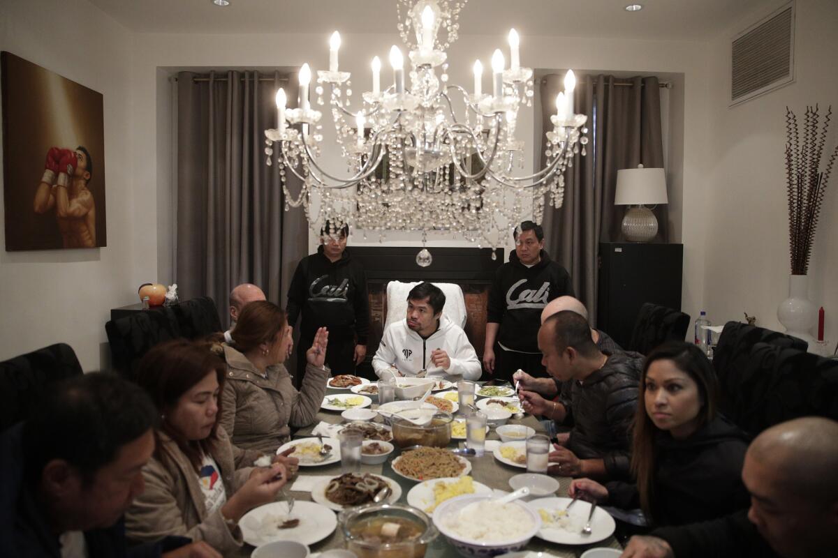 Manny Pacquiao, center, eats breakfast with friends and relatives following his morning run in Los Angeles. A spokesman for boxer Manny Pacquiao says the famed fighter's Los Angeles home was robbed at about the time he was in the ring with rival Adrien Broner in Las Vegas. Spokesman Mike Quinn confirmed the burglary to NBC News. Los Angeles police said a burglary was reported about 4:15 p.m. Sunday, Jan. 20, 2019. in the Larchmont neighborhood.