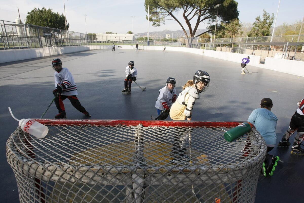 Children play at the Ralph Foy Park roller hockey rink in Burbank on Friday, March 14, 2014.