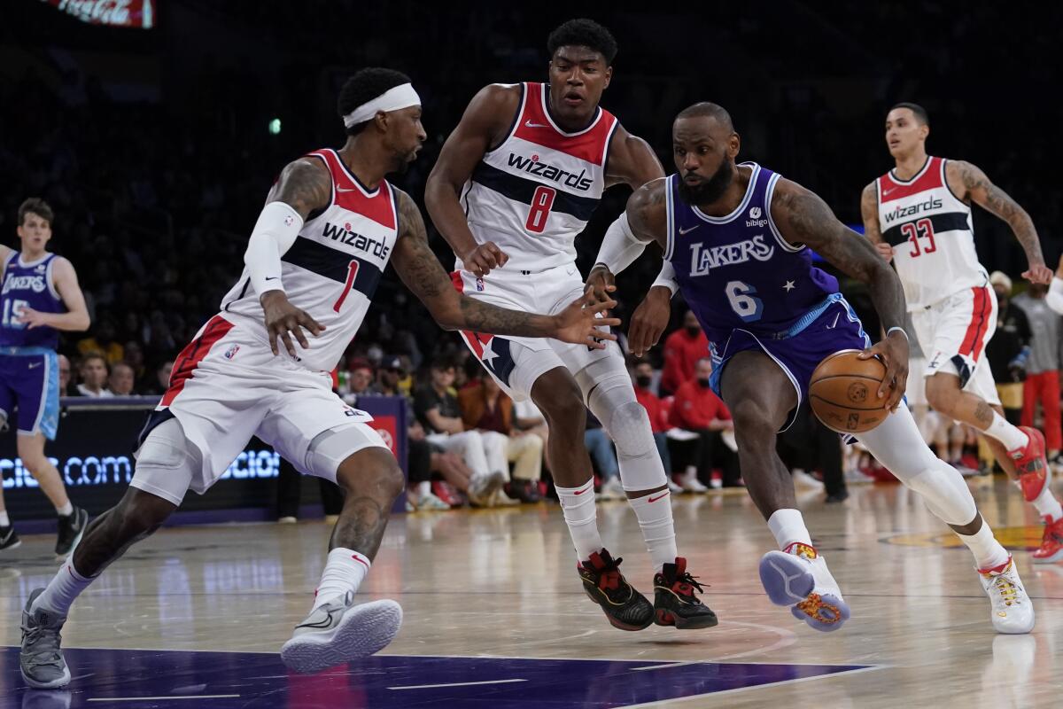 Lakers forward LeBron James draws a crowd of Wizards defenders as he drives toward the basket.
