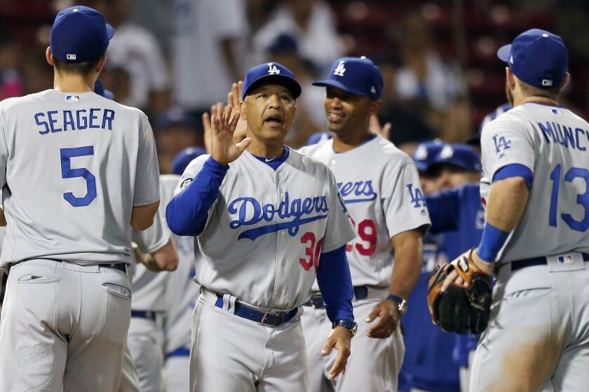 Los Angeles Dodgers manager Dave Roberts (30) celebrates with his team after defeating the Boston Red Sox in the 12th inning of a baseball game in Boston, Monday, July 15, 2019. (AP Photo/Michael Dwyer)