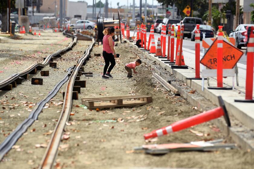 Santa Ana -May 10, 2021: A child plays along rail tracks in Santa Ana, construction is underway for a light-rail system, dubbed OC Streetcar, that is scheduled to be completed by 2023. (Wally Skalij / Los Angeles Times)