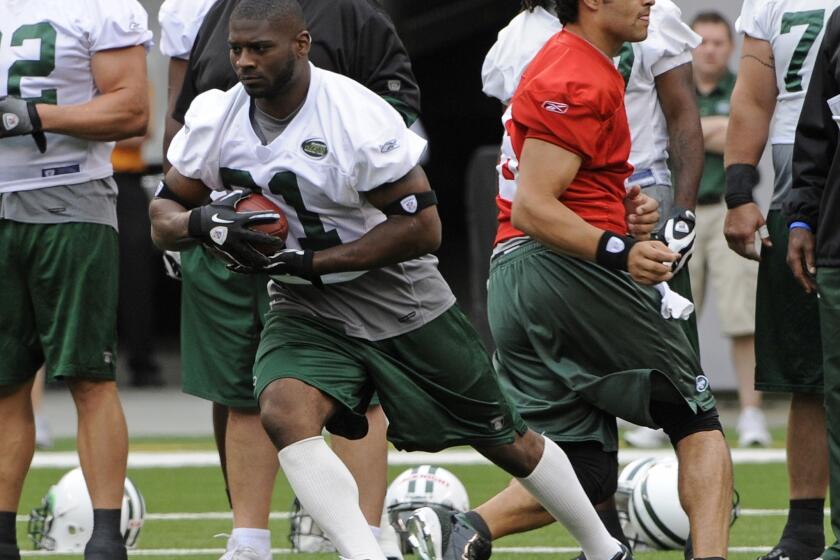 LaDainian Tomlinson takes a handoff from Mark Sanchez during New York Jets training camp back in 2010.