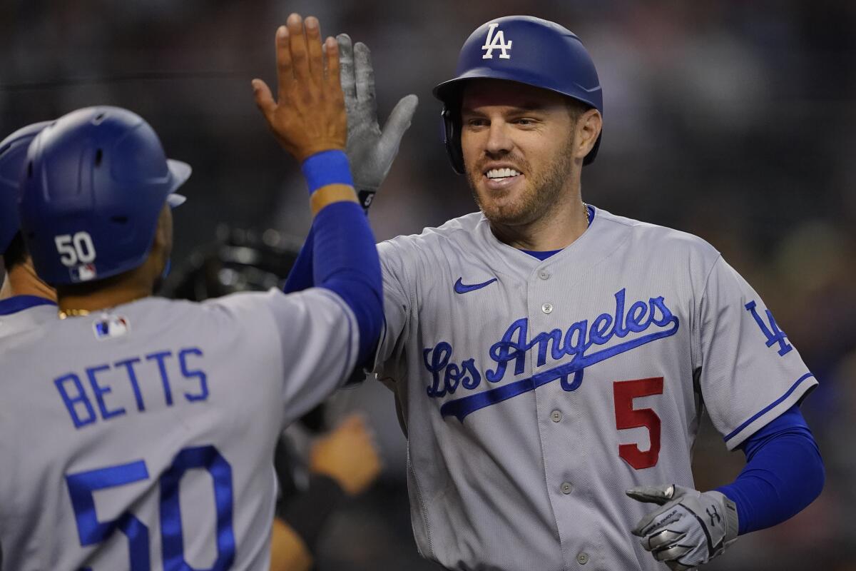 Dodgers' Freddie Freeman high fives Mookie Betts after hitting a three-run home run against the Arizona Diamondbacks.